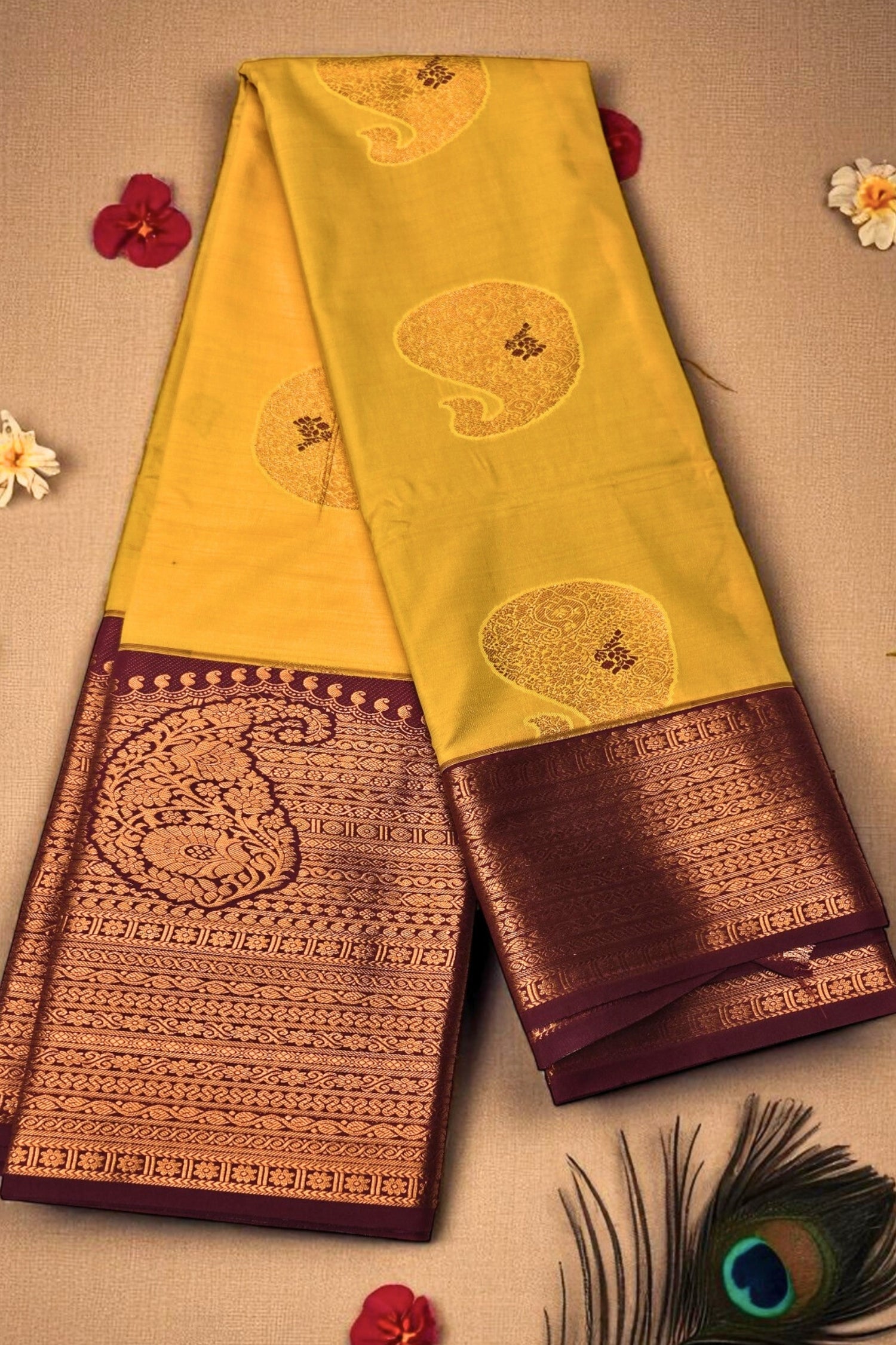 Yellow and brown saree with intricate patterns on a beige background
