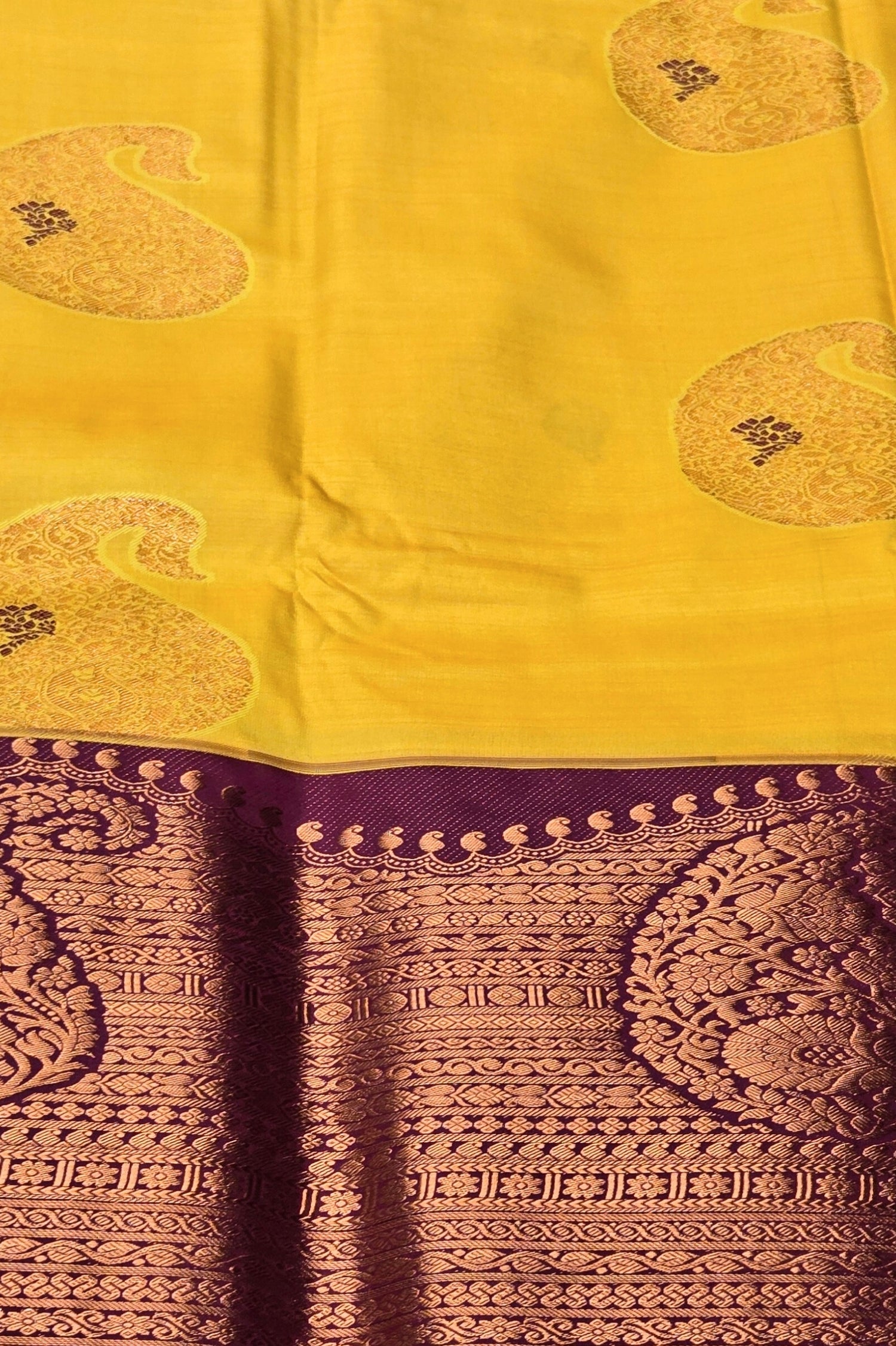 Yellow saree with purple border and intricate patterns
