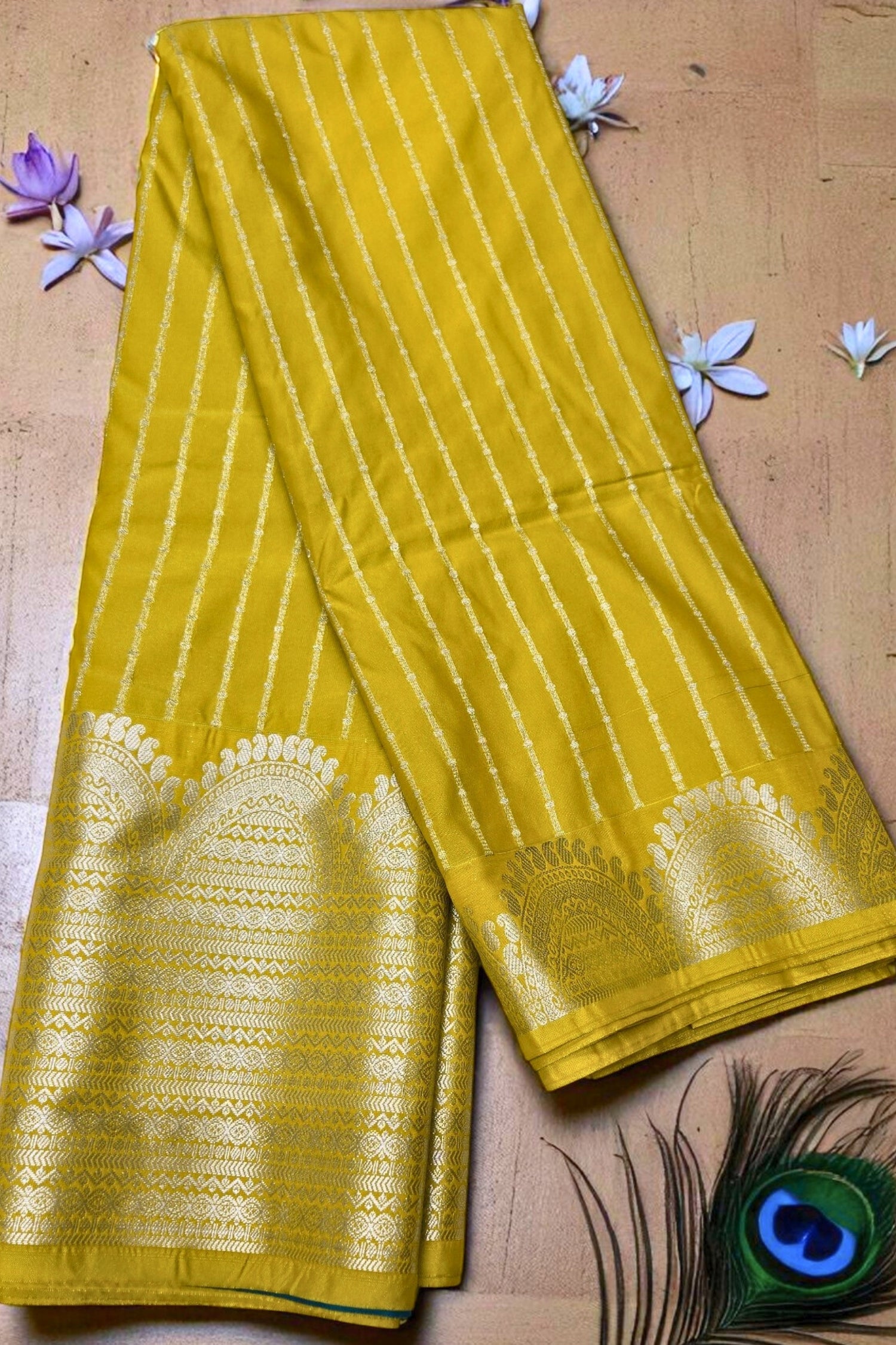 Yellow saree with white patterns on a wooden surface