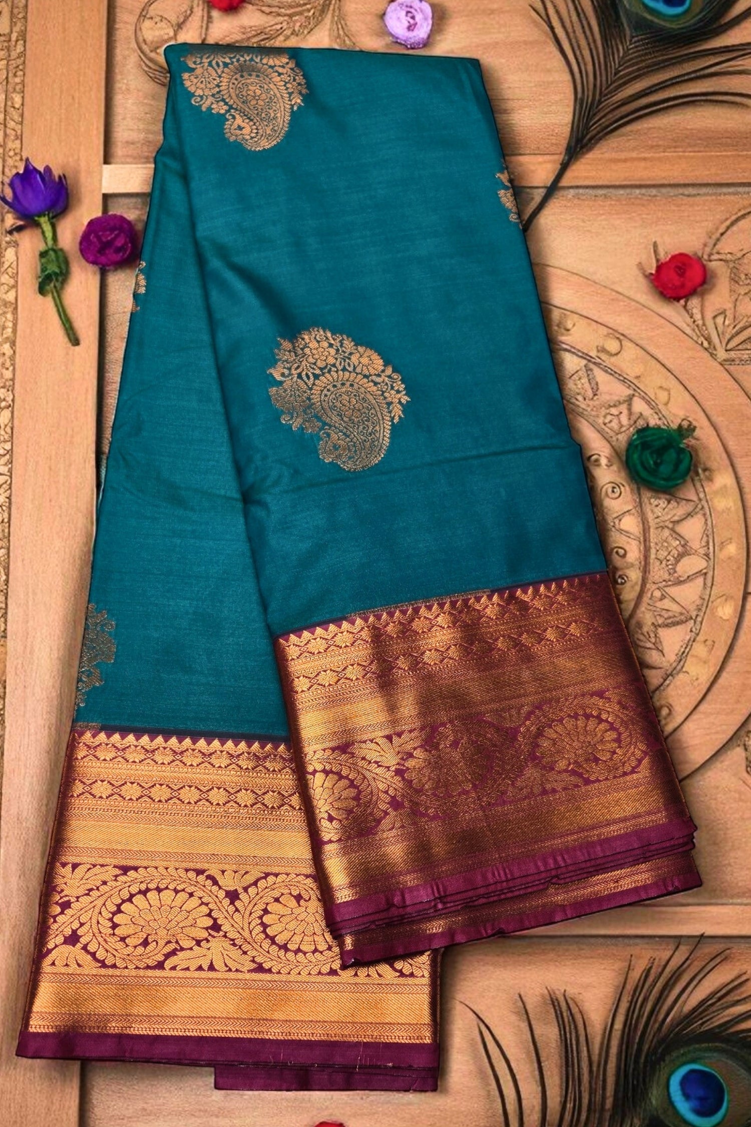 Teal saree with gold and purple border on a wooden background