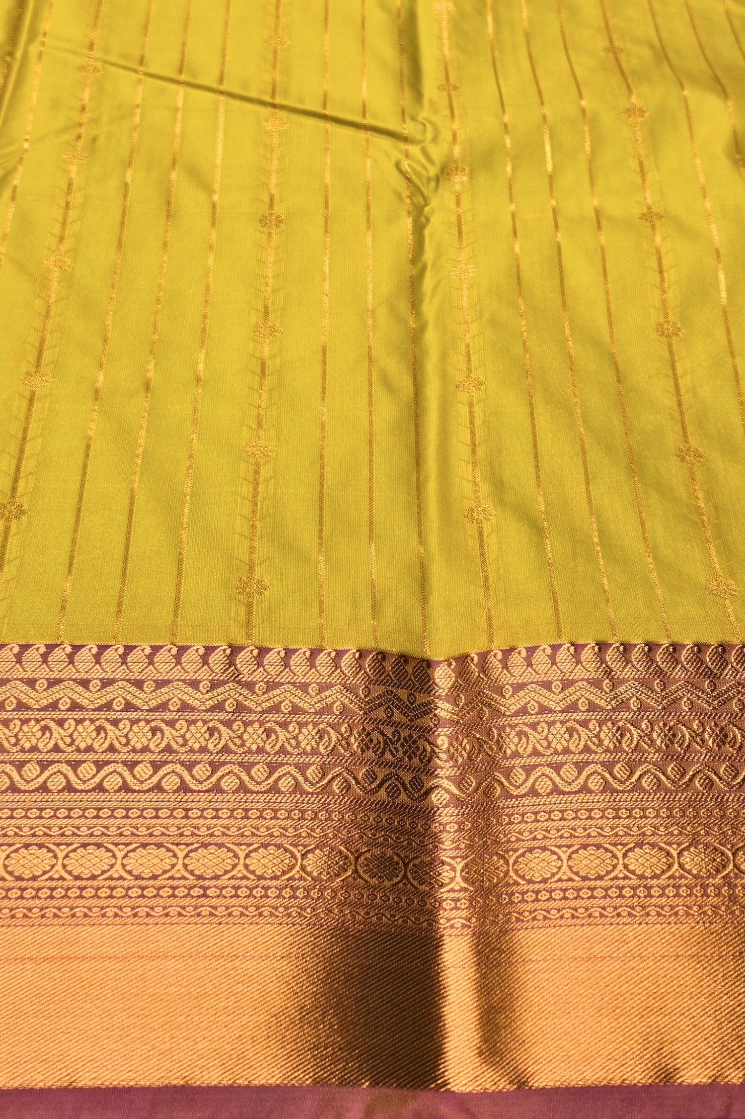 Close-up of a green and gold fabric with intricate patterns