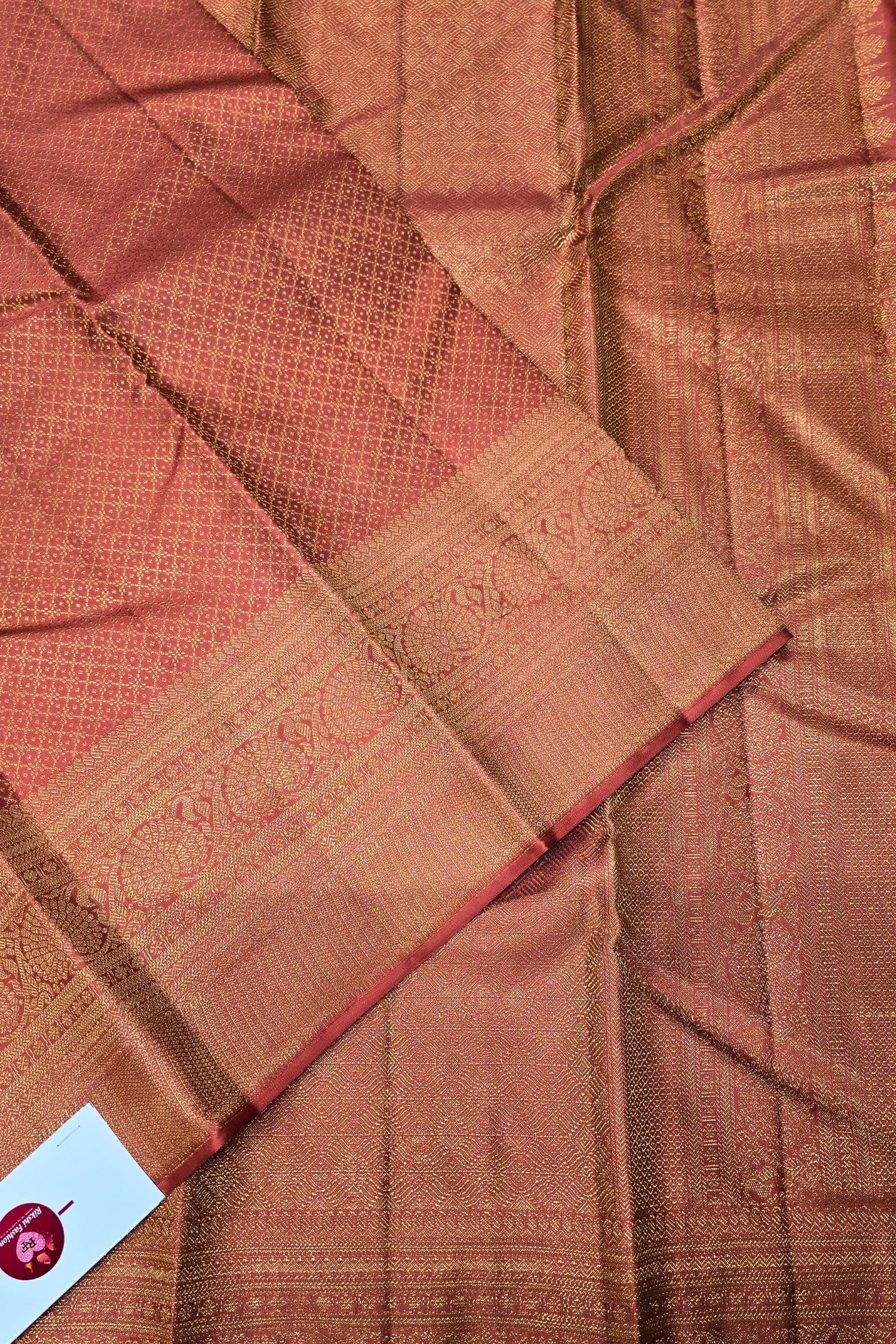 Close-up of brown fabric with intricate patterns and a label in the corner.