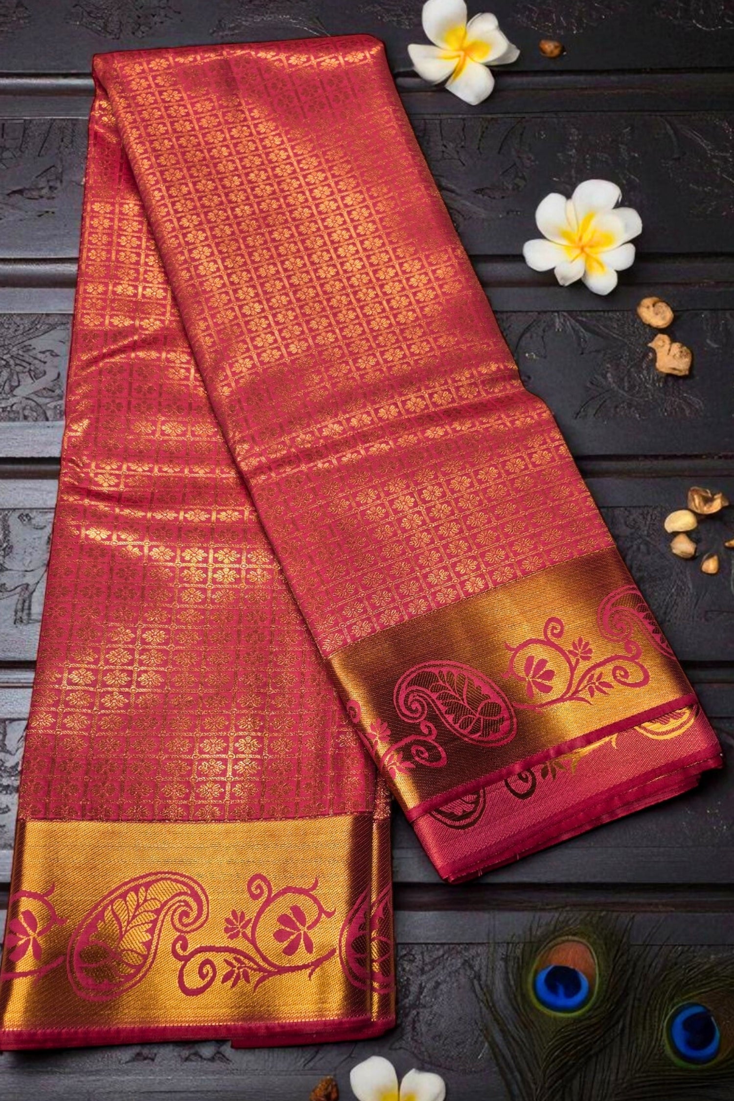Red and gold saree with intricate patterns on a dark surface