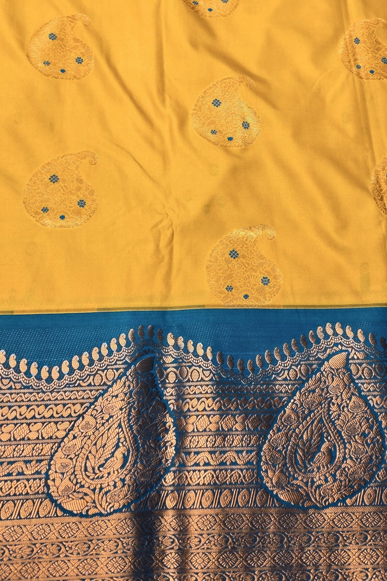 Yellow fabric with intricate patterns and a blue border