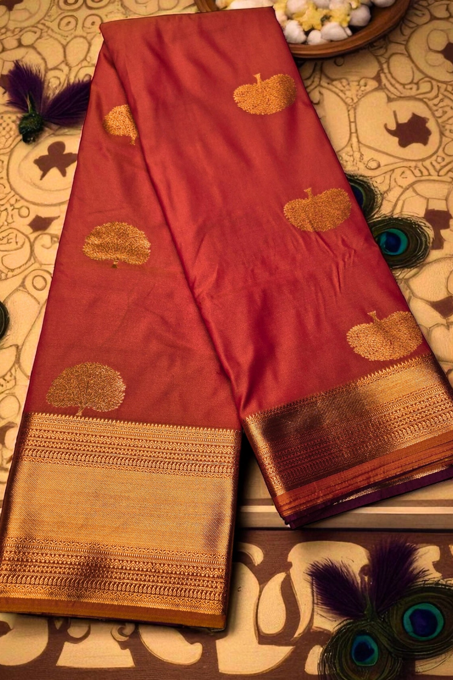 Red saree with gold patterns on a decorative background