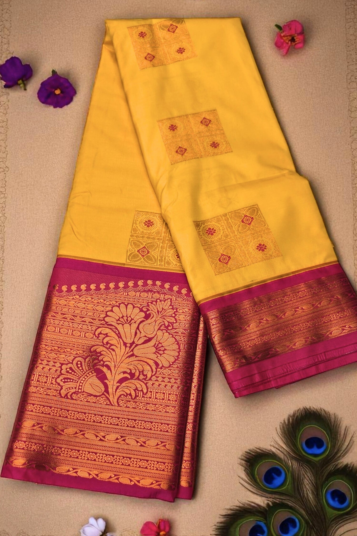 Yellow saree with pink and gold border on a beige background