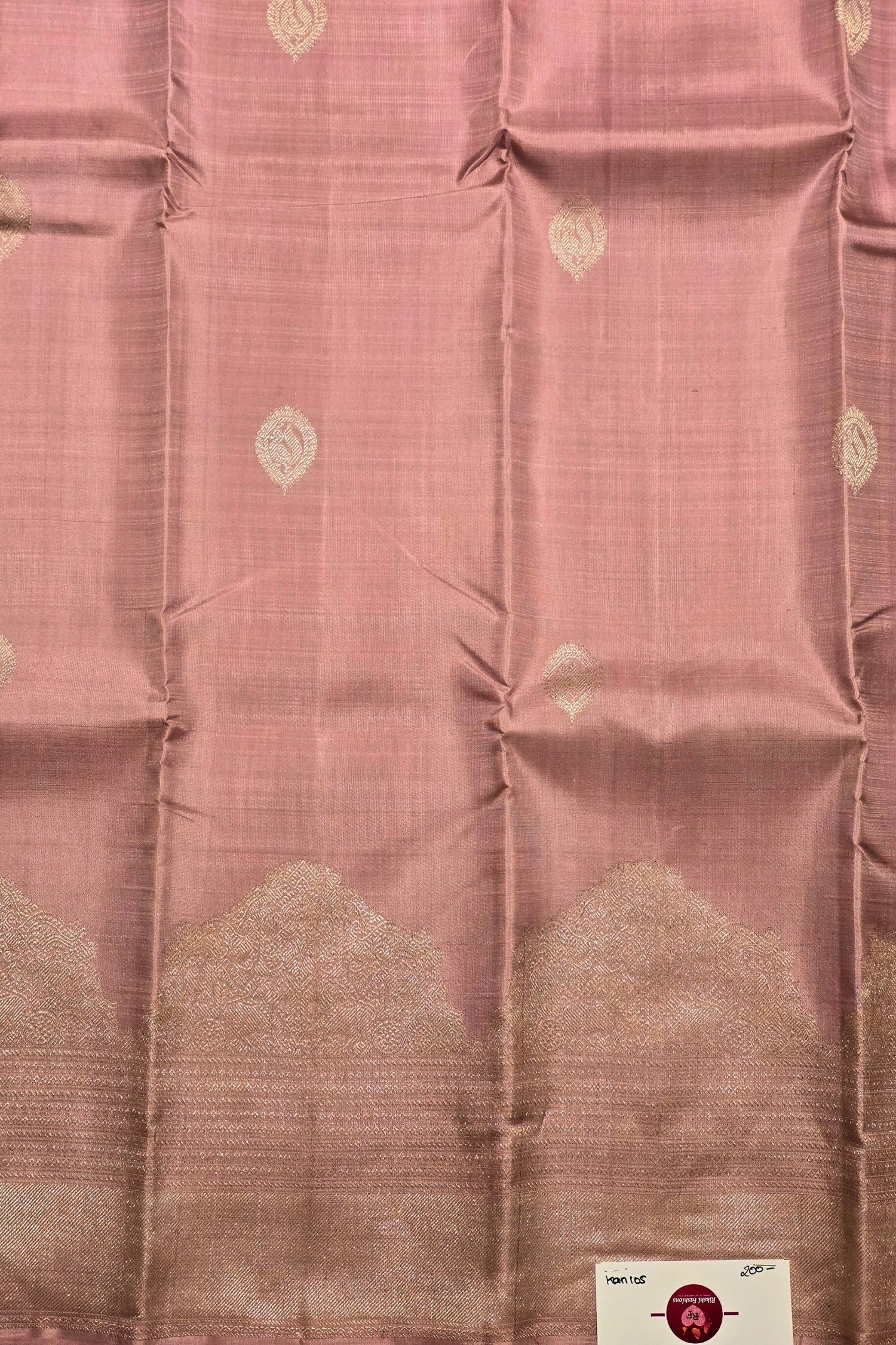 Pink fabric with a subtle pattern and a visible brand label.