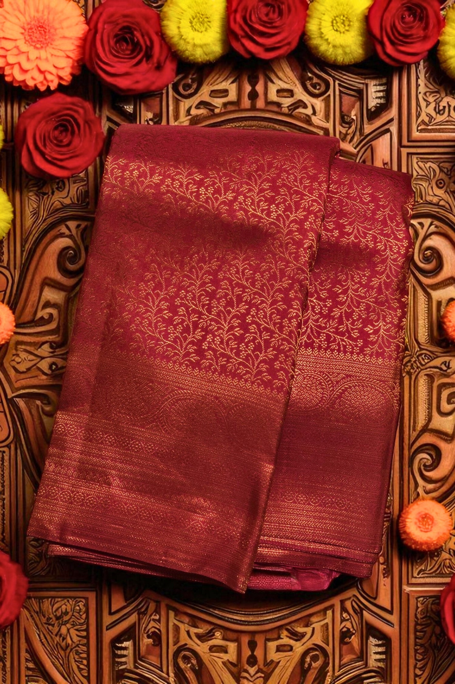 Maroon saree with floral patterns on a decorative background with flowers