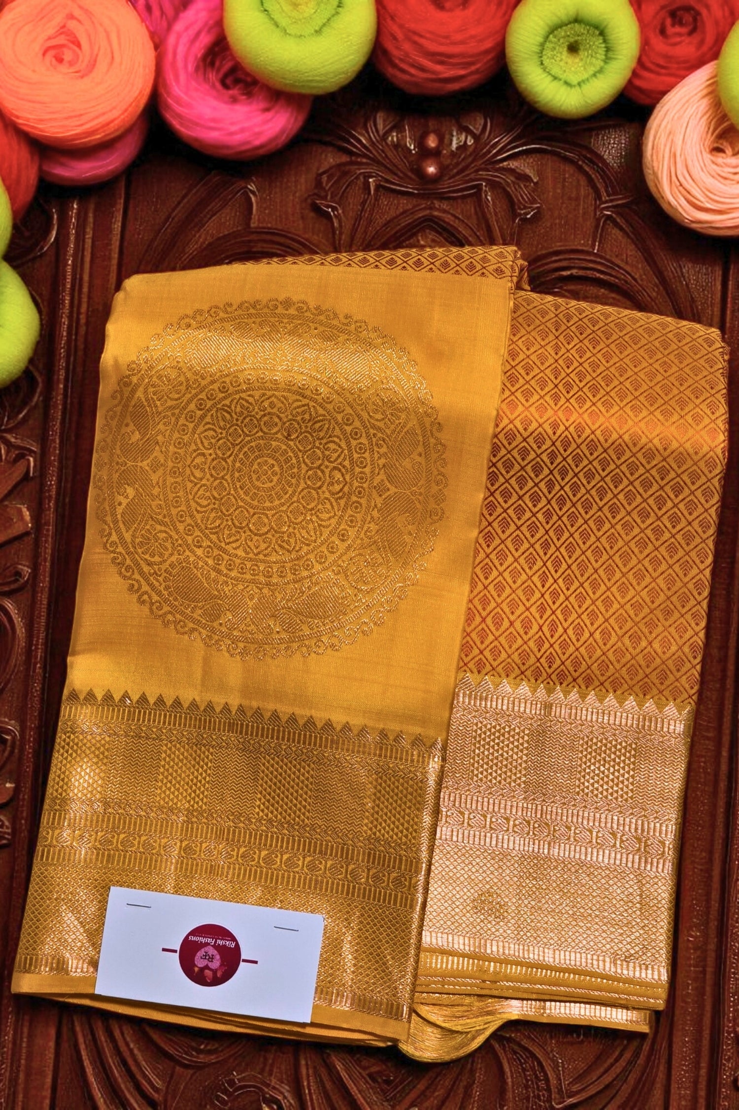 Yellow saree with intricate patterns on a wooden background