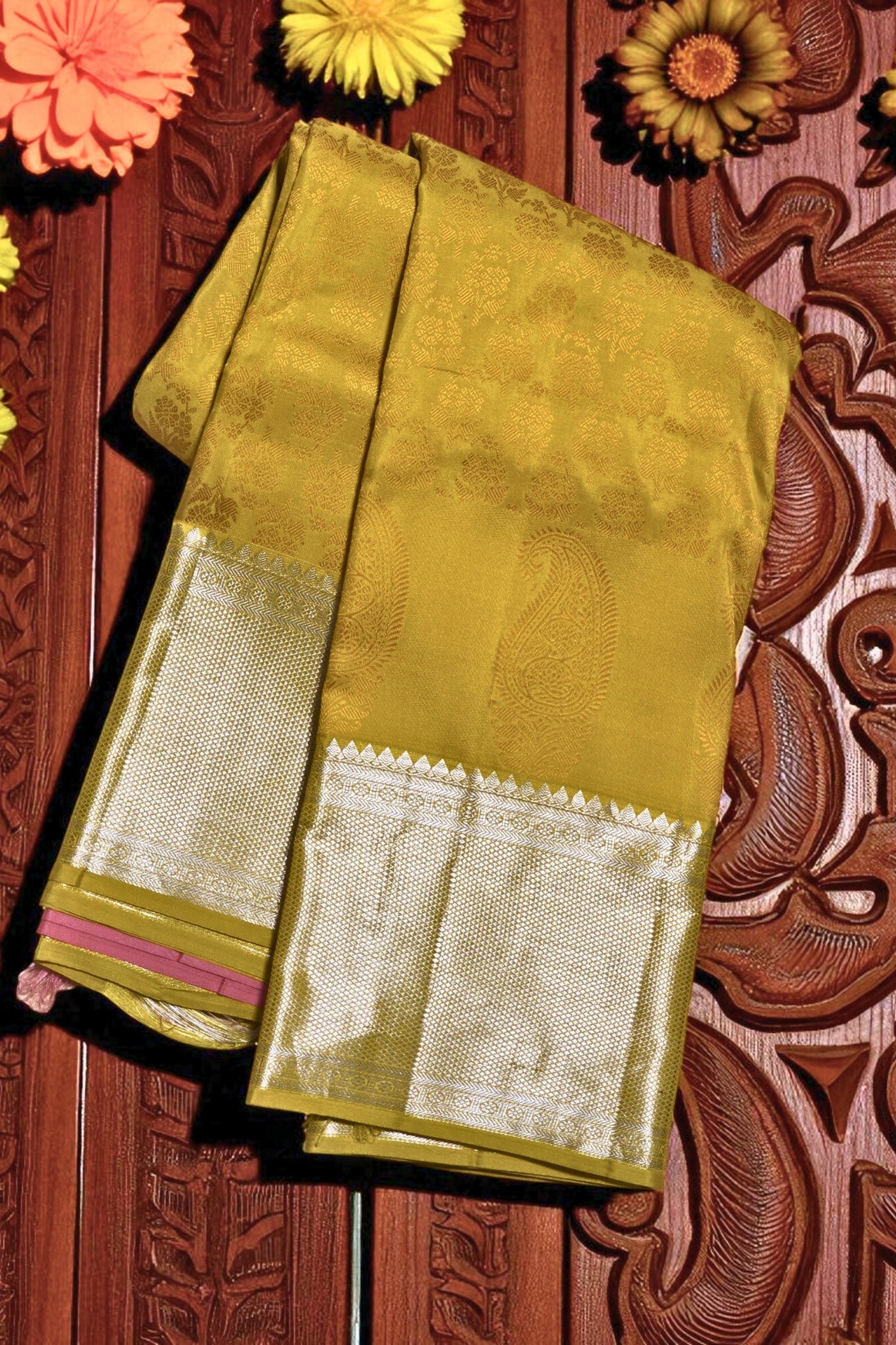 Green saree with white border on a decorative wooden background
