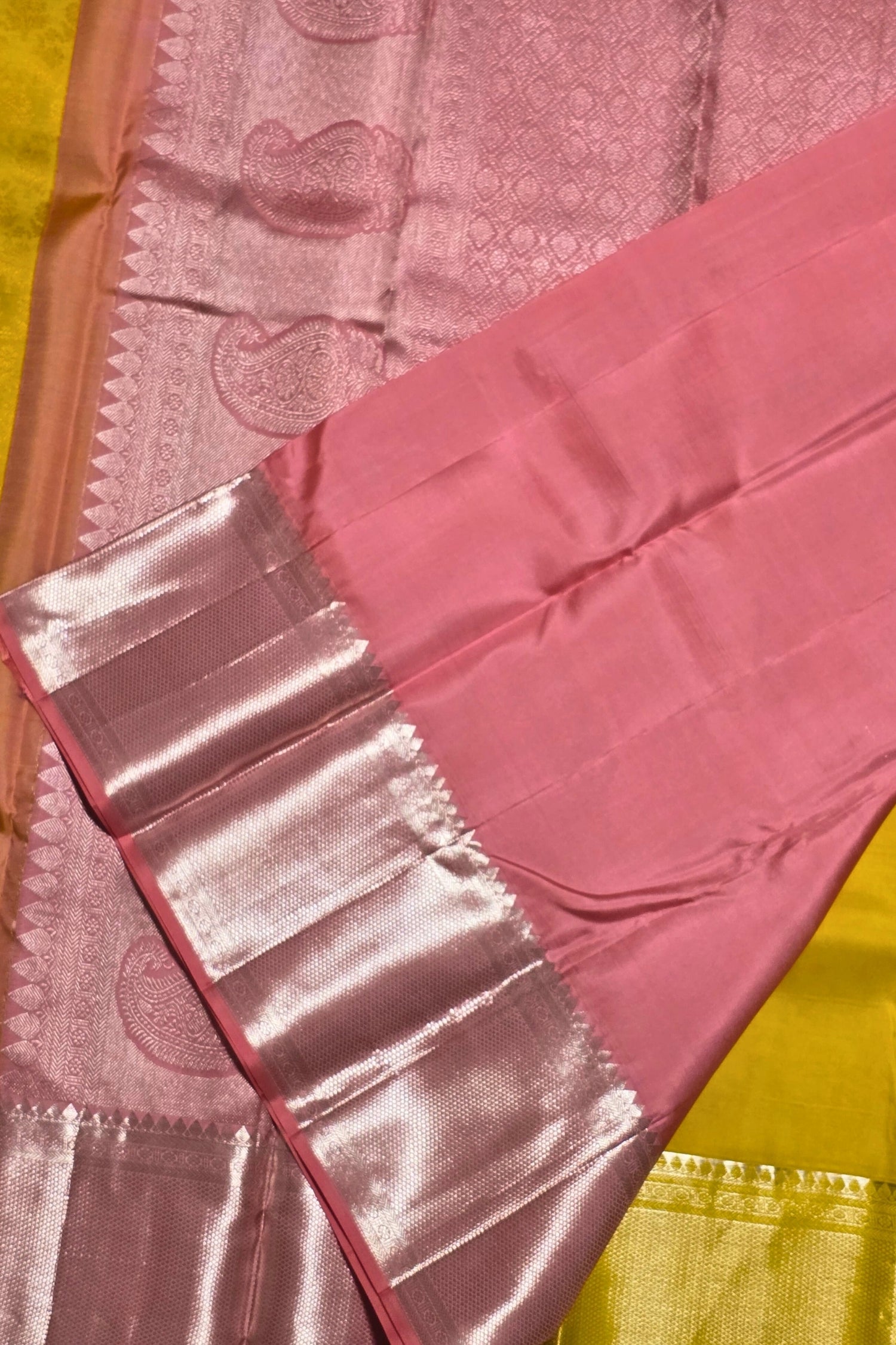 Pink saree with a decorative border on a yellow background