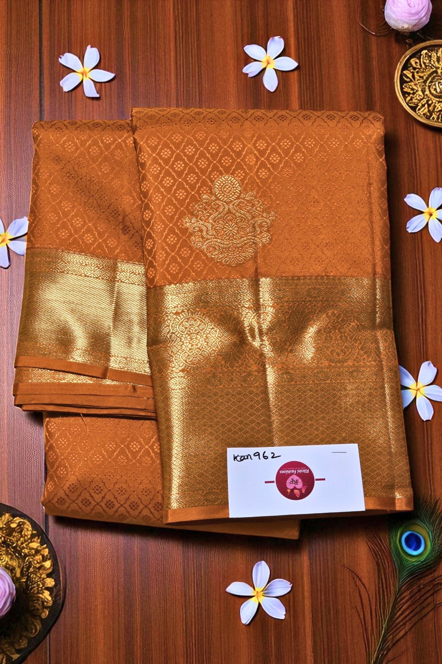 Brown saree with gold border on a wooden background with decorative elements