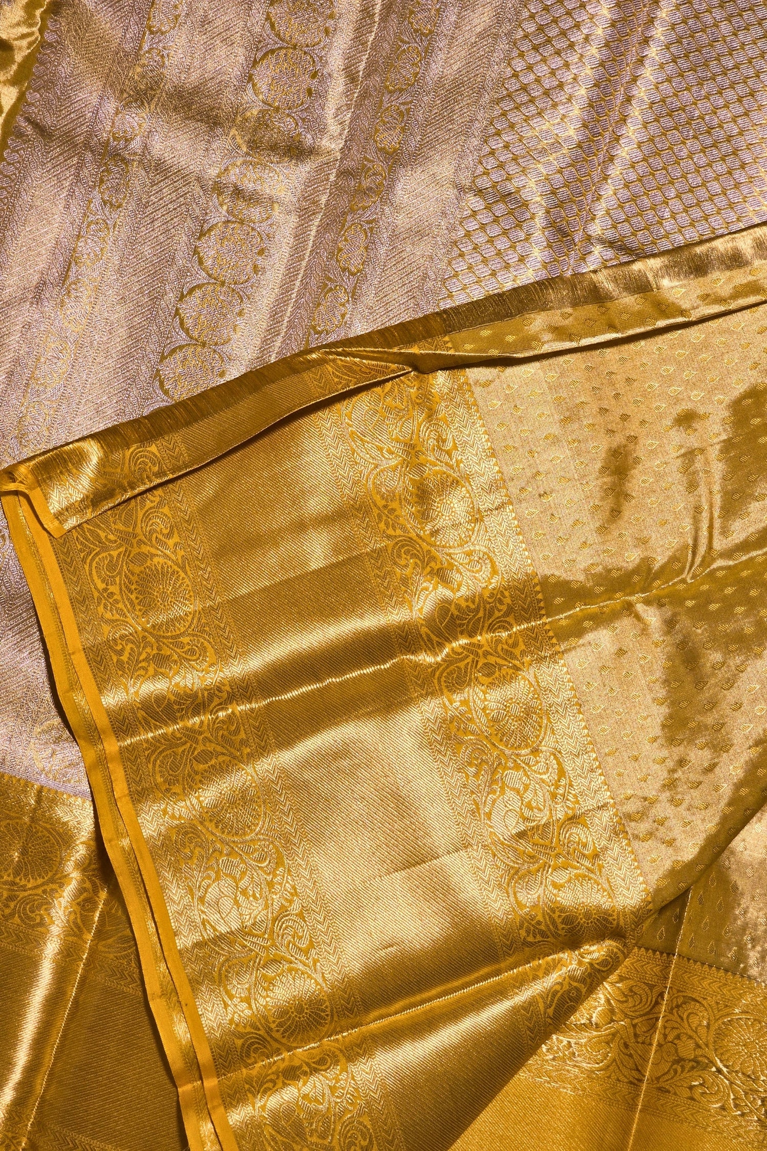 Close-up of a gold fabric with intricate patterns on a textured background
