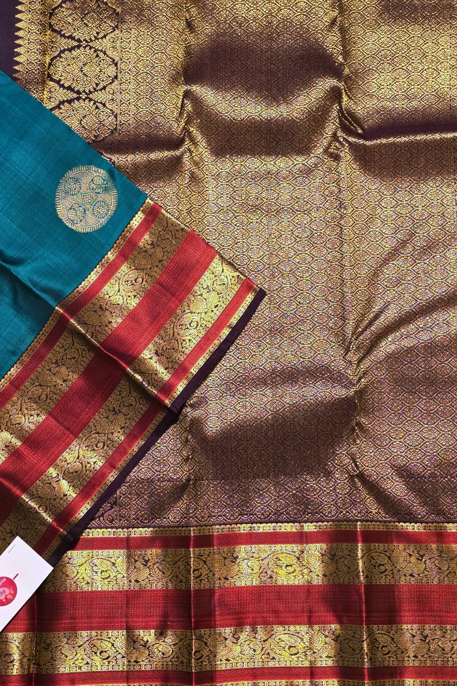Traditional saree with a blue border and red and gold patterns on a brown background