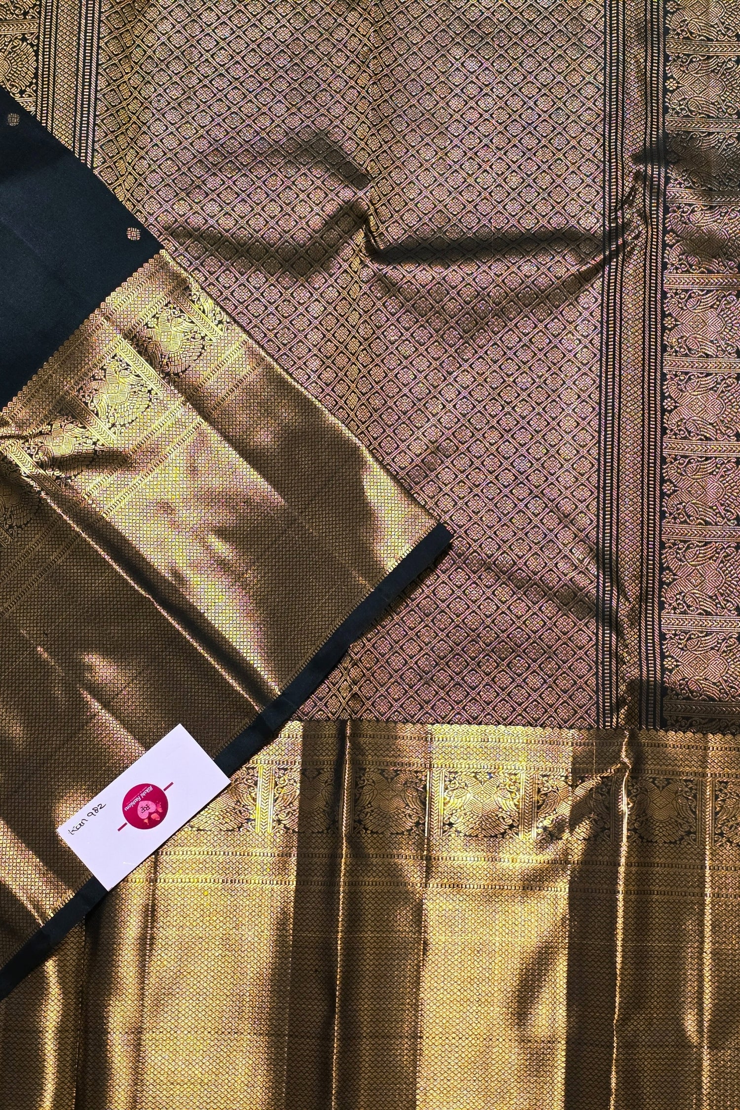 Gold fabric with intricate patterns and a visible brand label.