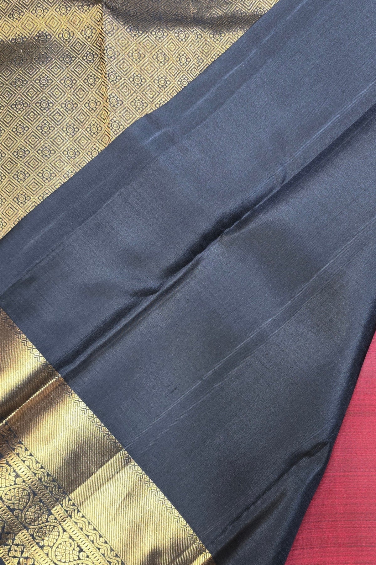 Dark blue fabric with gold border on a textured surface