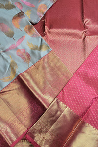 Close-up of a fabric with pink, gold, and multicolor patterns.