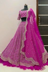 Pink embroidered lehenga on a mannequin against a neutral wall.