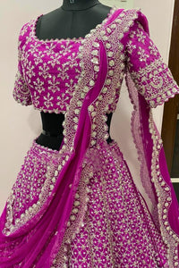 Purple embroidered traditional outfit on a mannequin against a white wall.