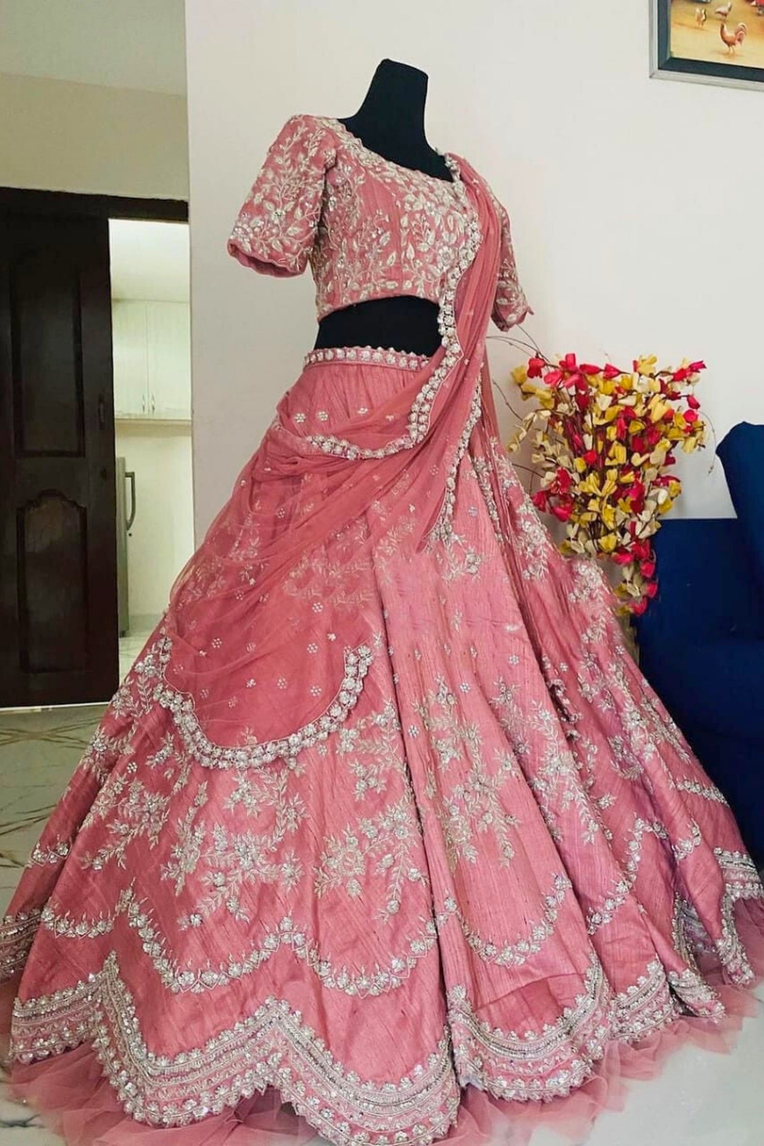 Pink embroidered saree with black blouse on a mannequin against a neutral background