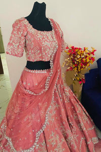 Pink embroidered saree with blouse on a mannequin against a neutral background