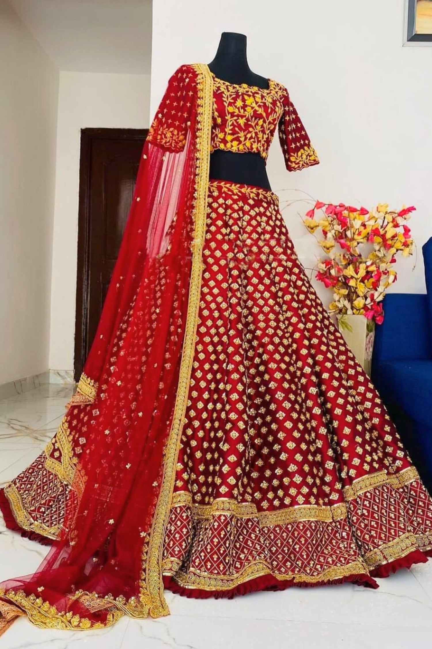 Red and gold traditional outfit on a mannequin with a white background