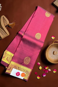 Pink saree with gold border on a brown background