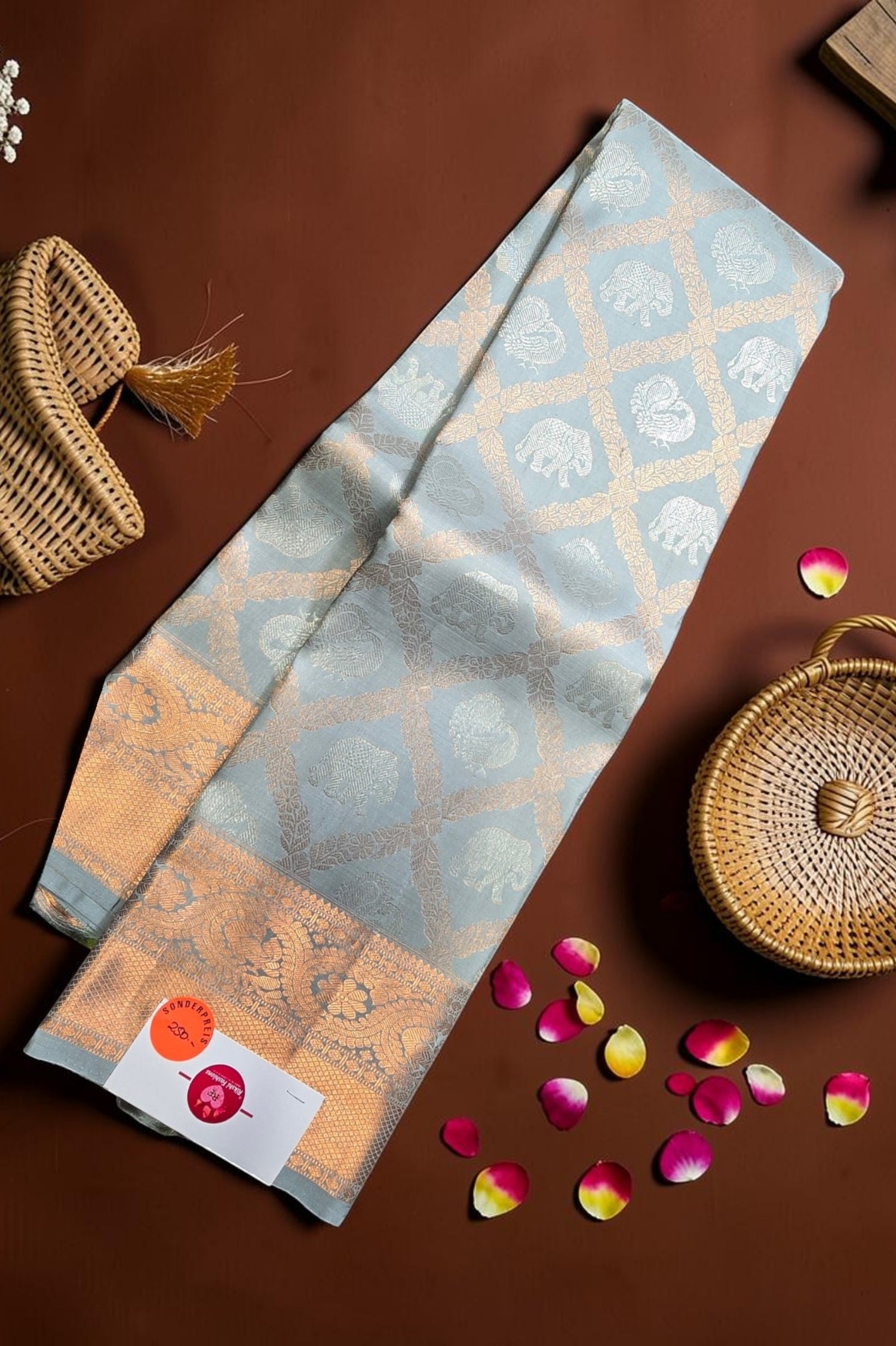 Patterned fabric with a woven basket and rose petals on a brown surface