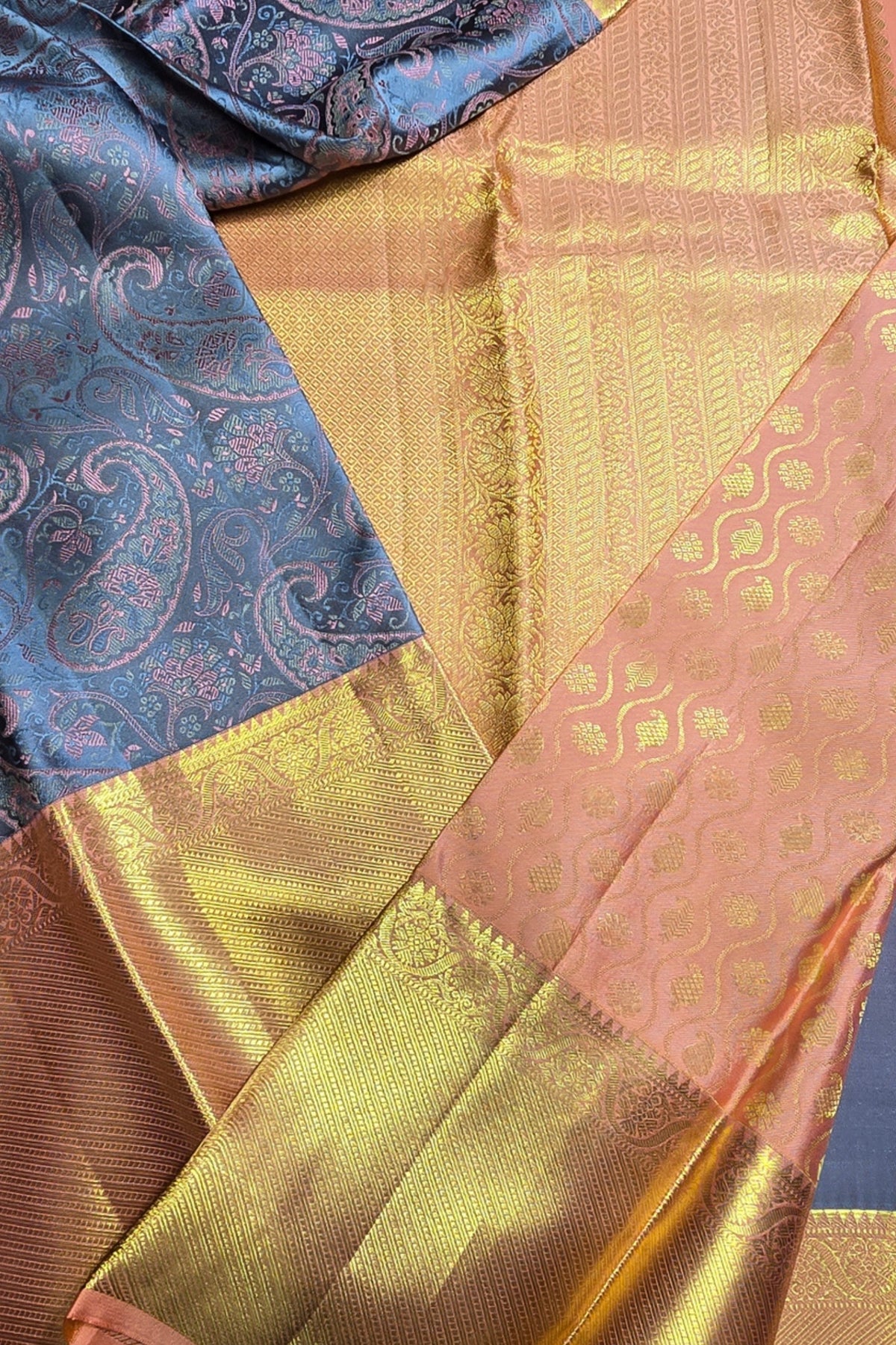 Close-up of a saree with blue, gold, and pink patterns.