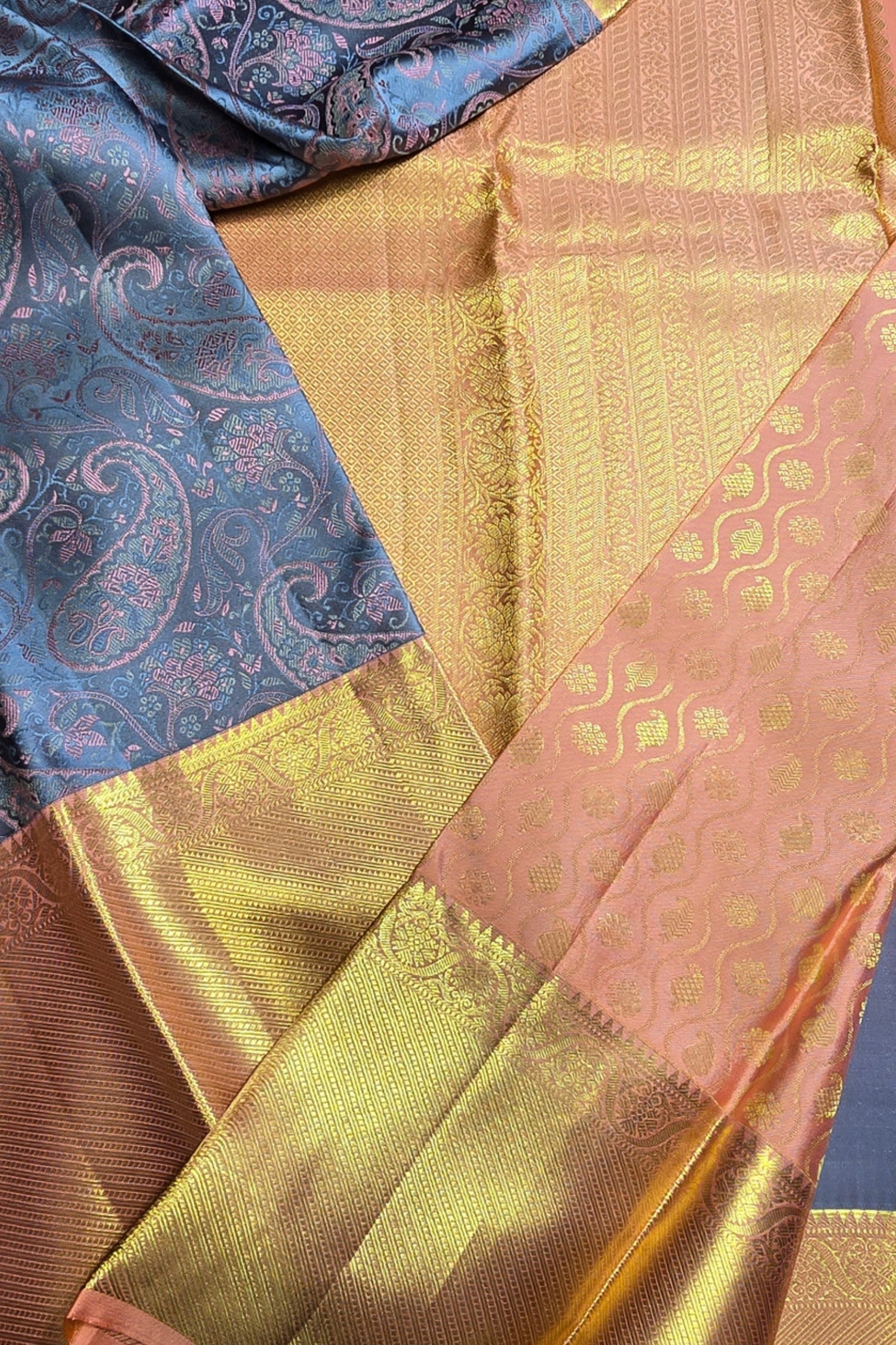 Close-up of a saree with blue, gold, and pink patterns.