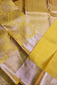 Close-up of a yellow fabric with intricate patterns and borders