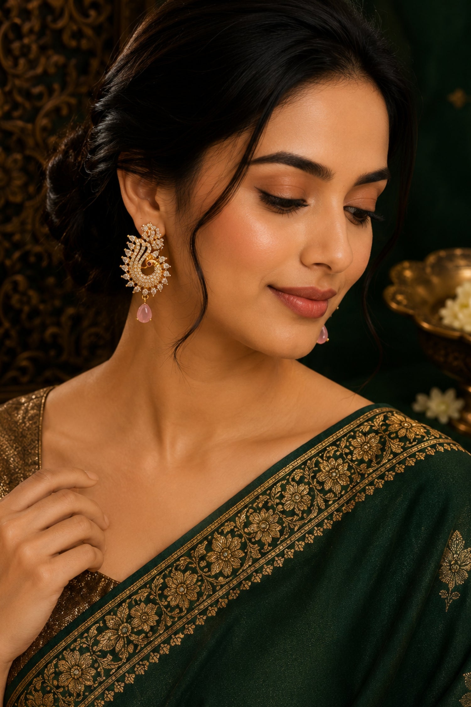 Woman wearing a dark green saree with gold embroidery, posing against a dark background.