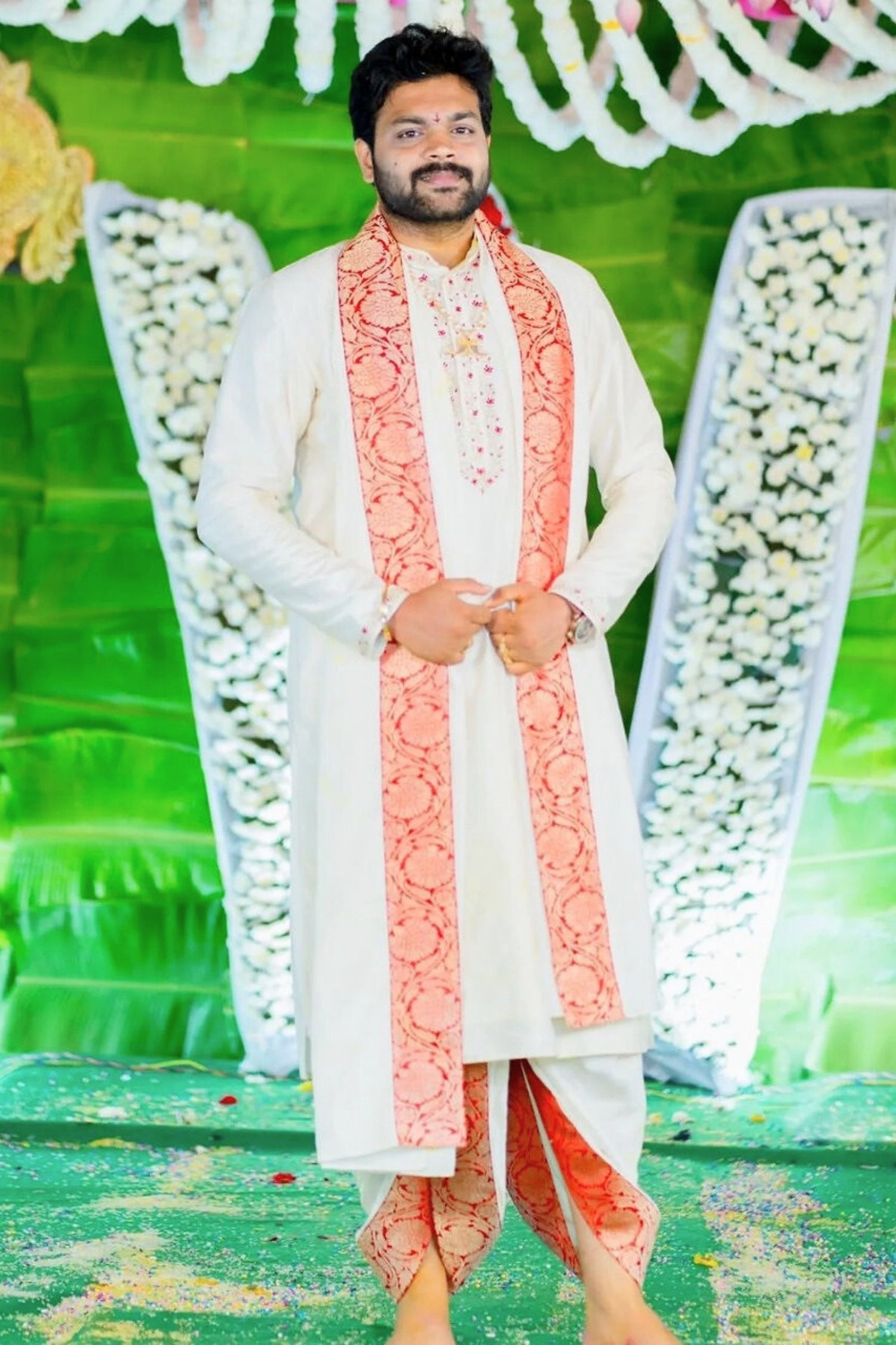Man in traditional attire with a decorative background