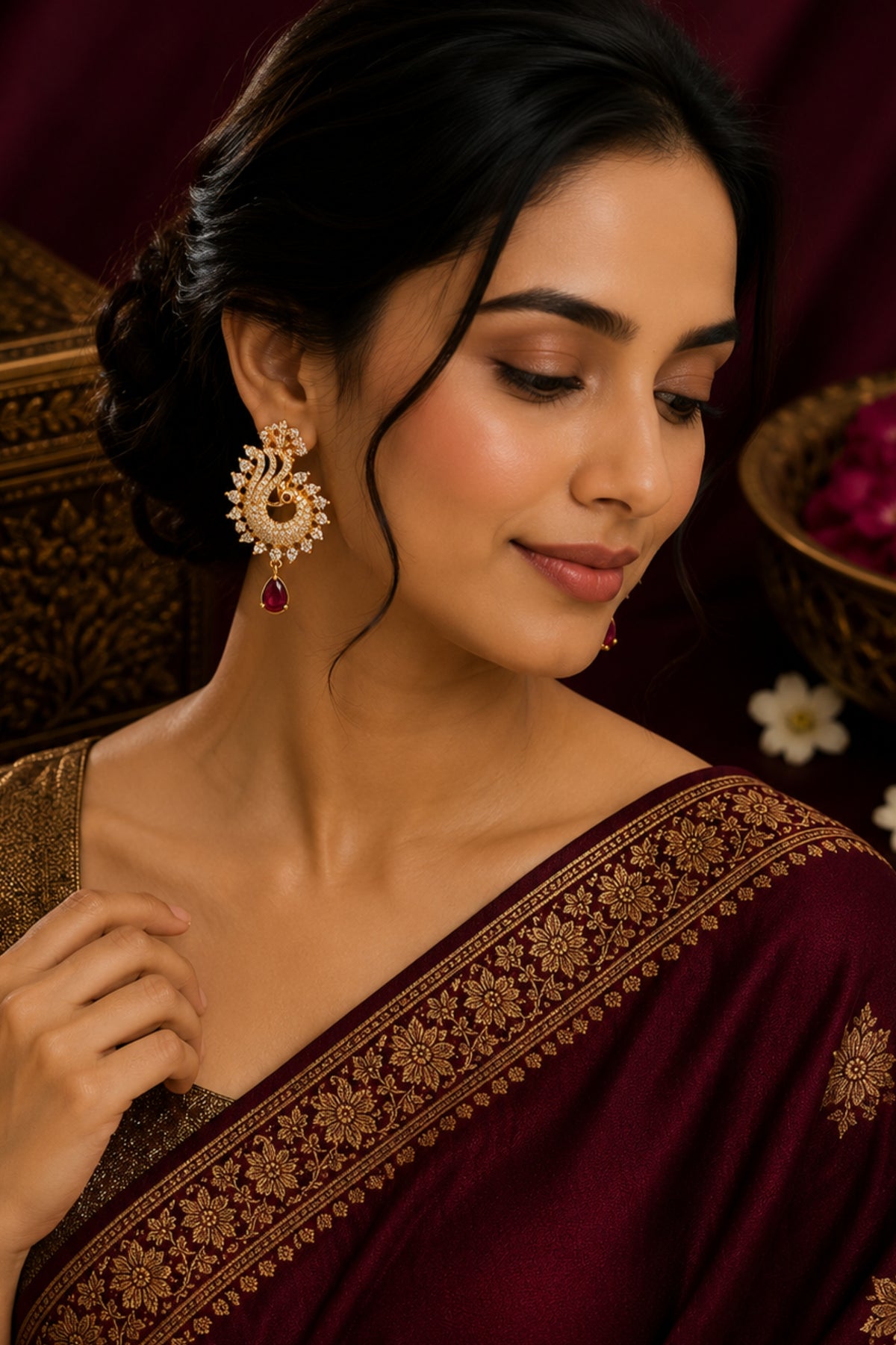 Woman wearing a maroon saree with gold embroidery, posing against a dark background.