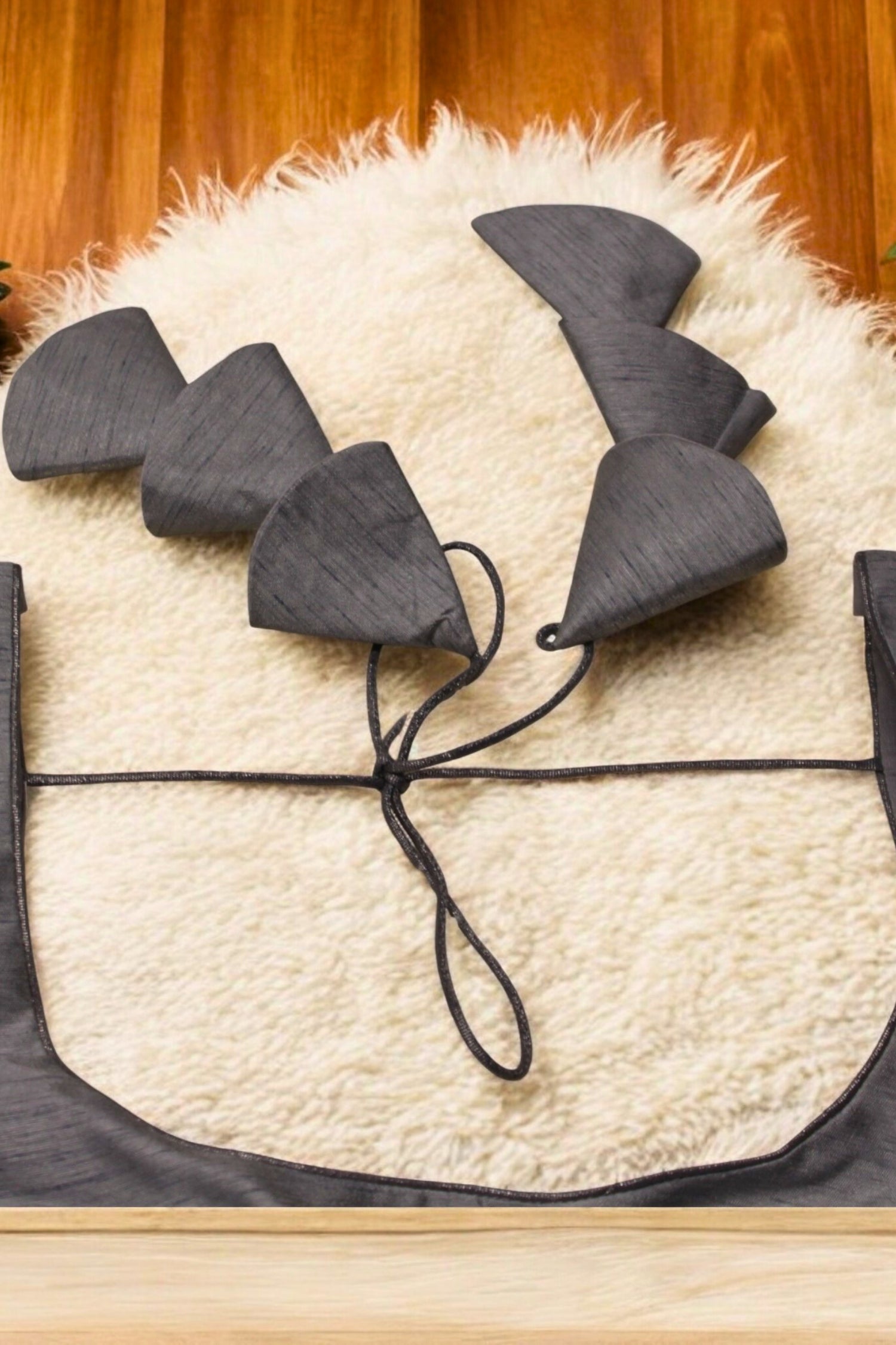 Black cat ears headband on a white pillow with a wooden background