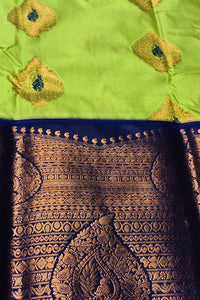 Traditional saree with intricate gold patterns on a green and blue background