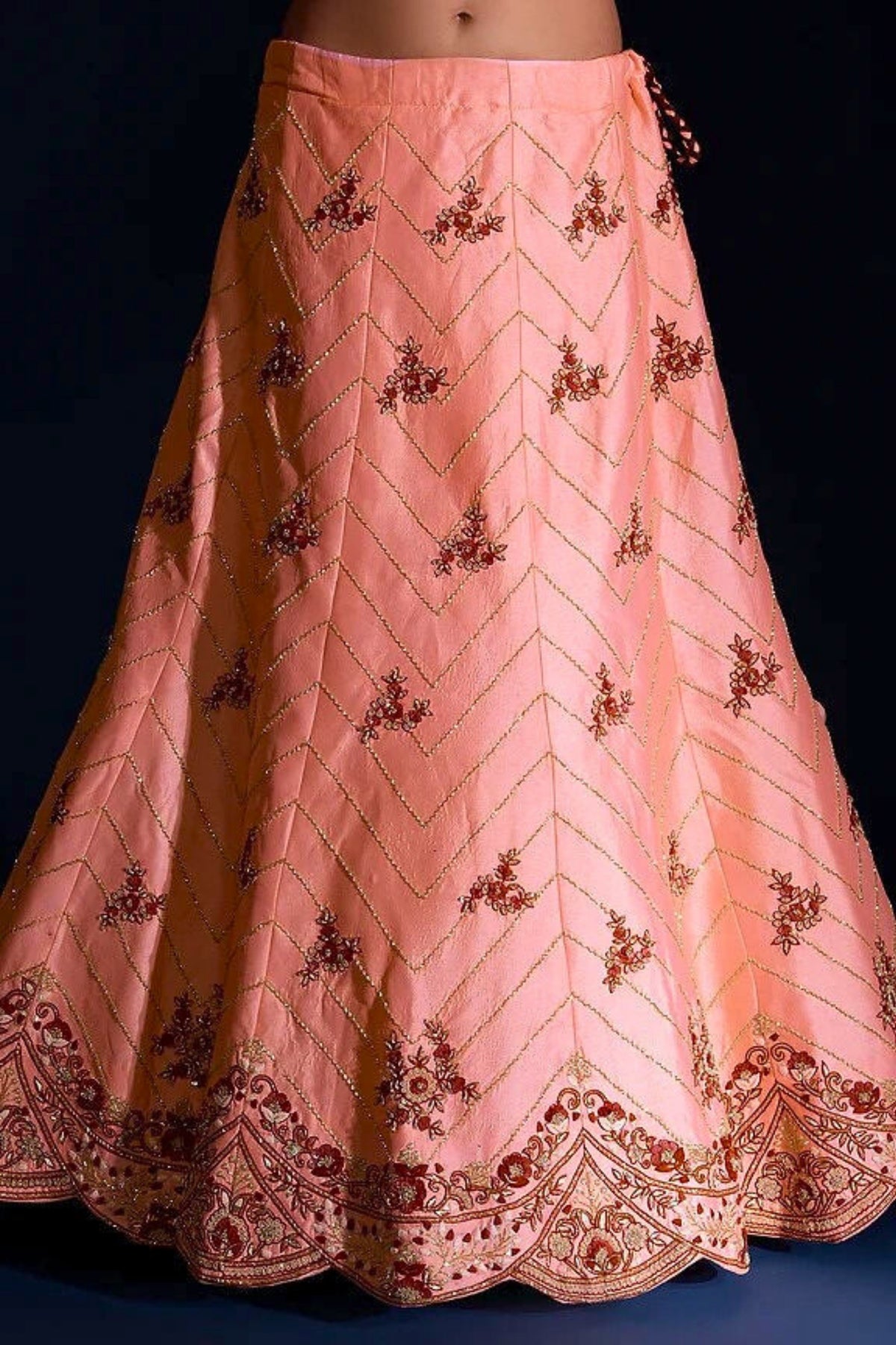 Peach-colored embroidered skirt on a black background