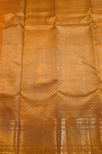 A close-up of a golden-orange silk fabric with a woven geometric pattern and a decorative border.