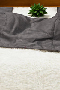Gray fabric with a plant on a white surface
