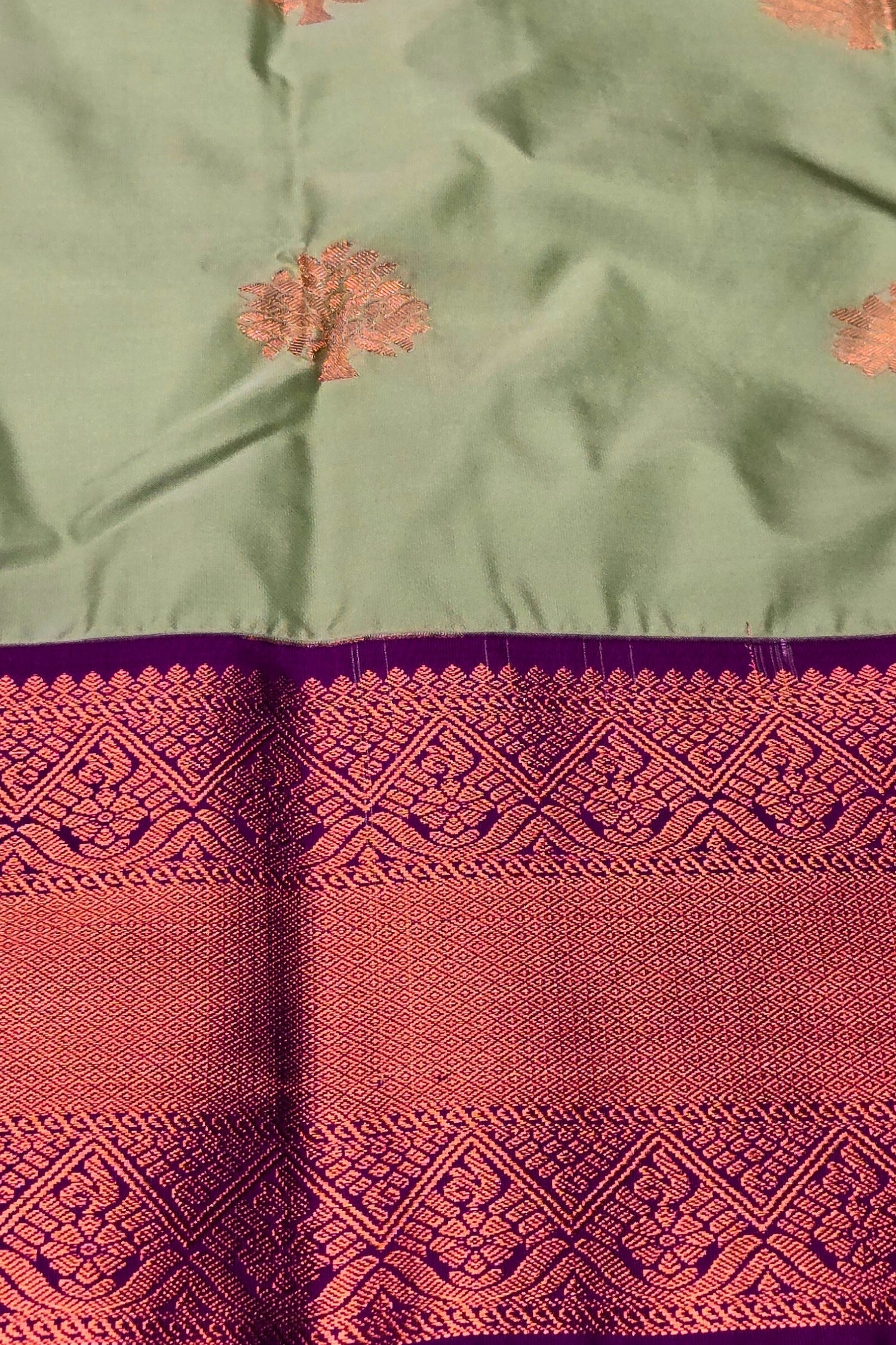 Green fabric with intricate red and purple patterns