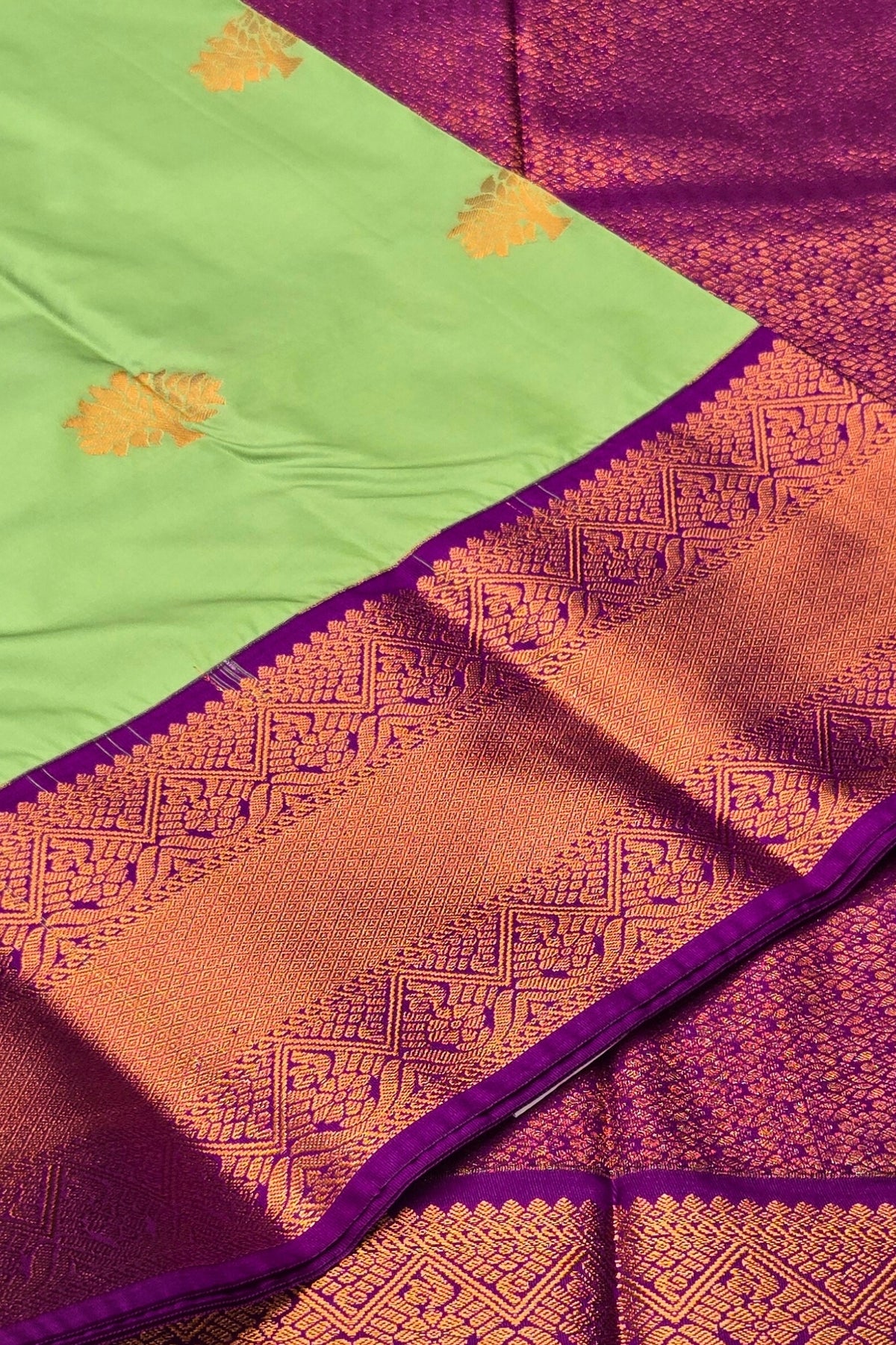 Saree with green, orange, and purple colors and intricate patterns.