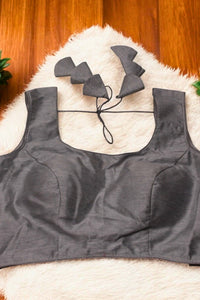 Gray sports bra and black wireless earbuds on a textured surface
