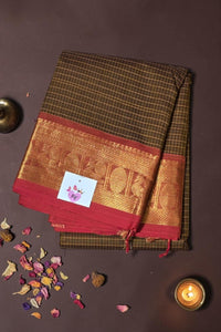 Brown and red saree with gold border on a dark background