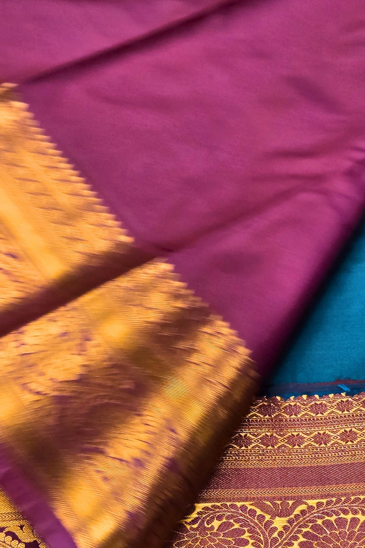 Close-up of a purple fabric with gold and blue patterns