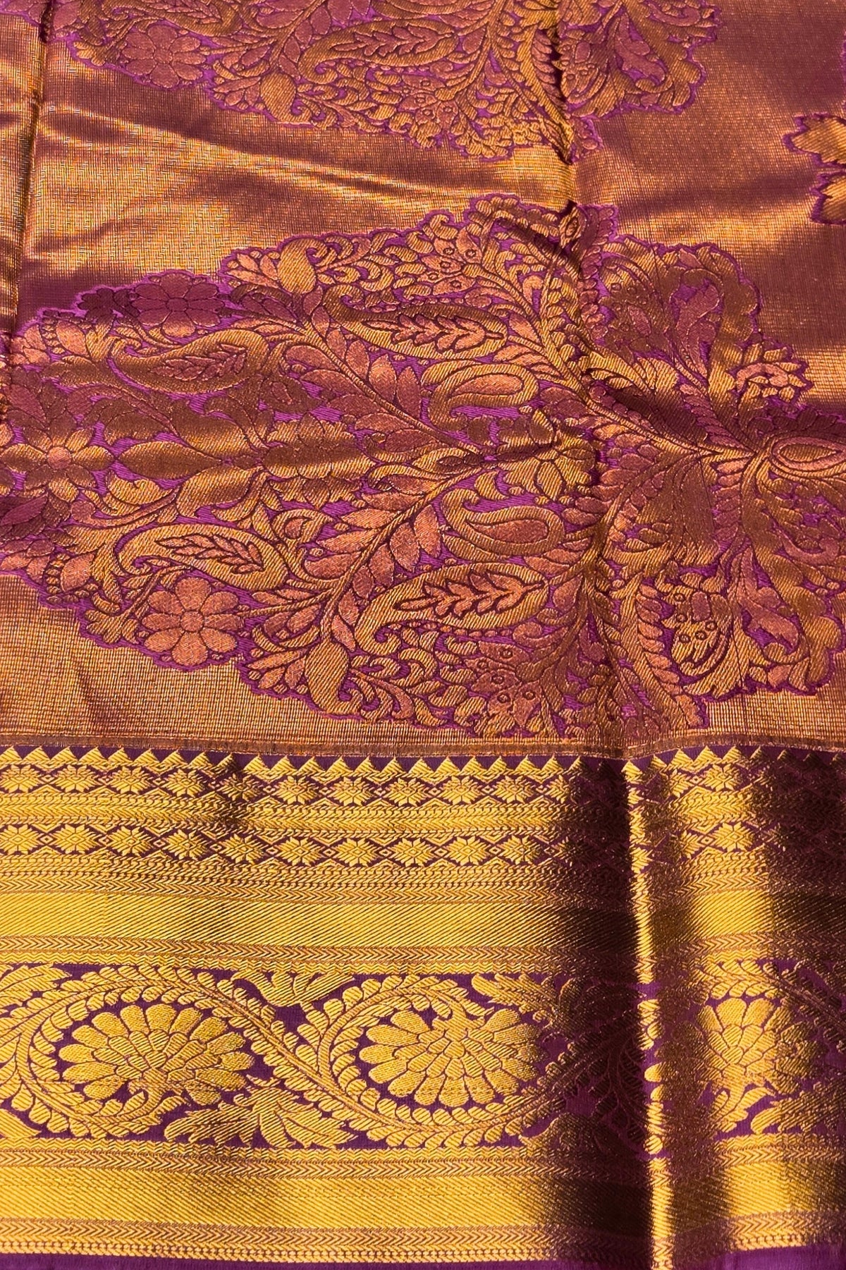 Close-up of a saree with intricate purple and gold patterns