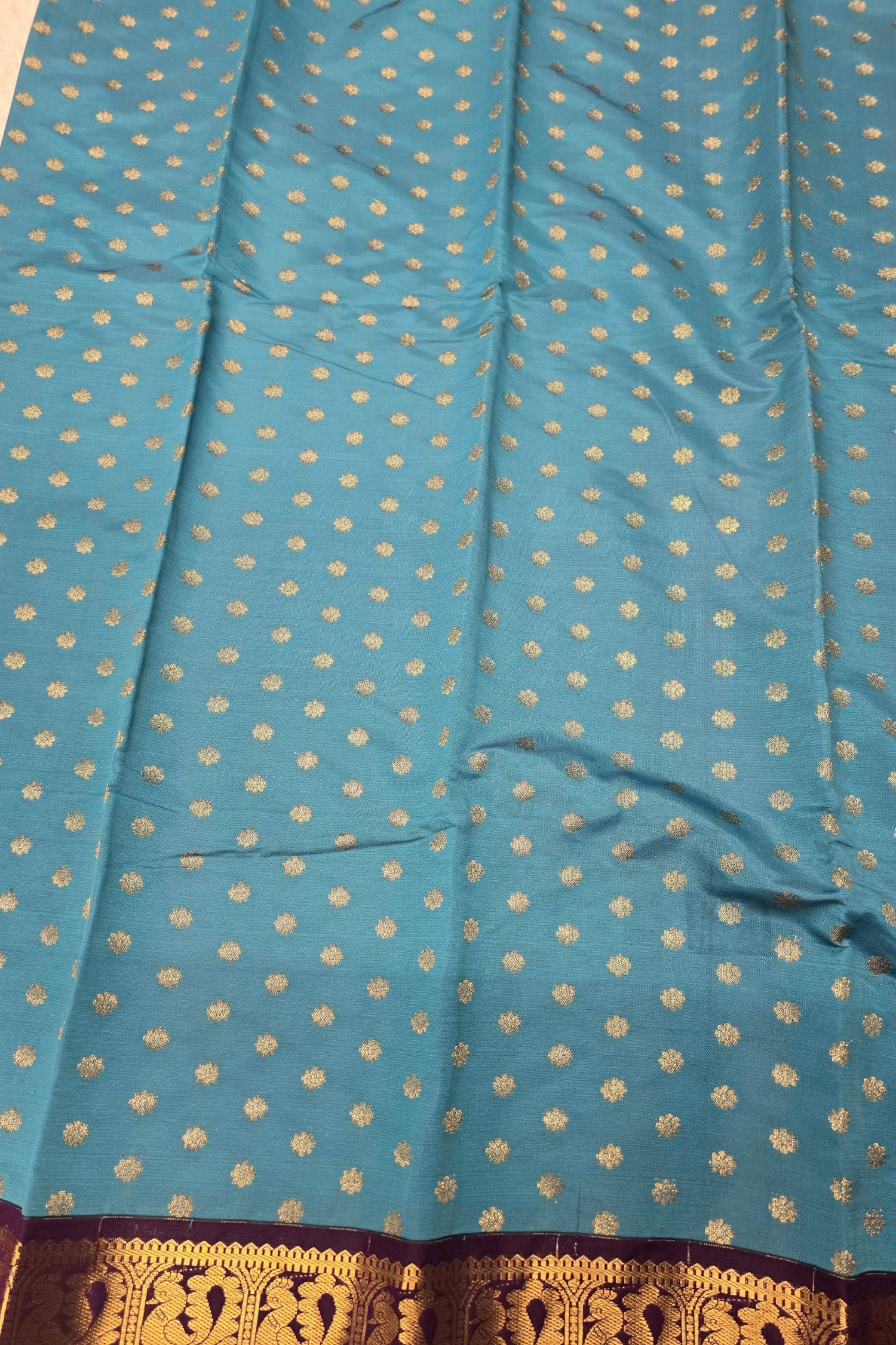 Blue fabric with gold polka dots and a brown border