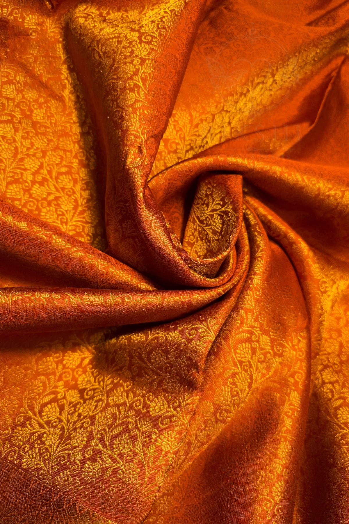 Orange Gold Floral Brocade Woven Fabric with intricate floral pattern and shimmering texture.