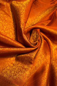 Orange Gold Floral Brocade Woven Fabric with intricate floral pattern and shimmering texture.