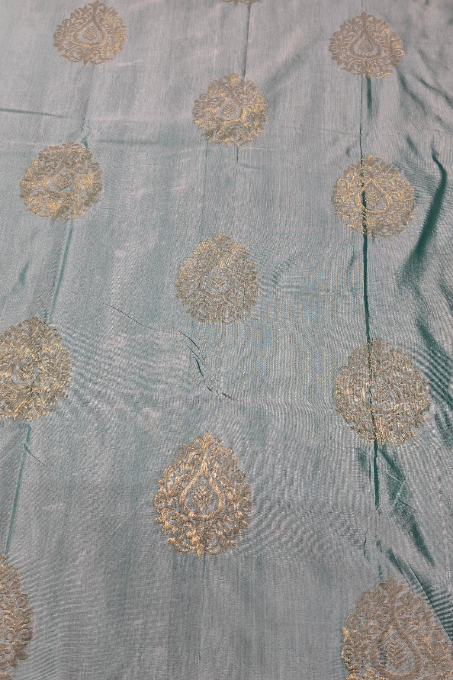 Light blue fabric with gold embroidered patterns