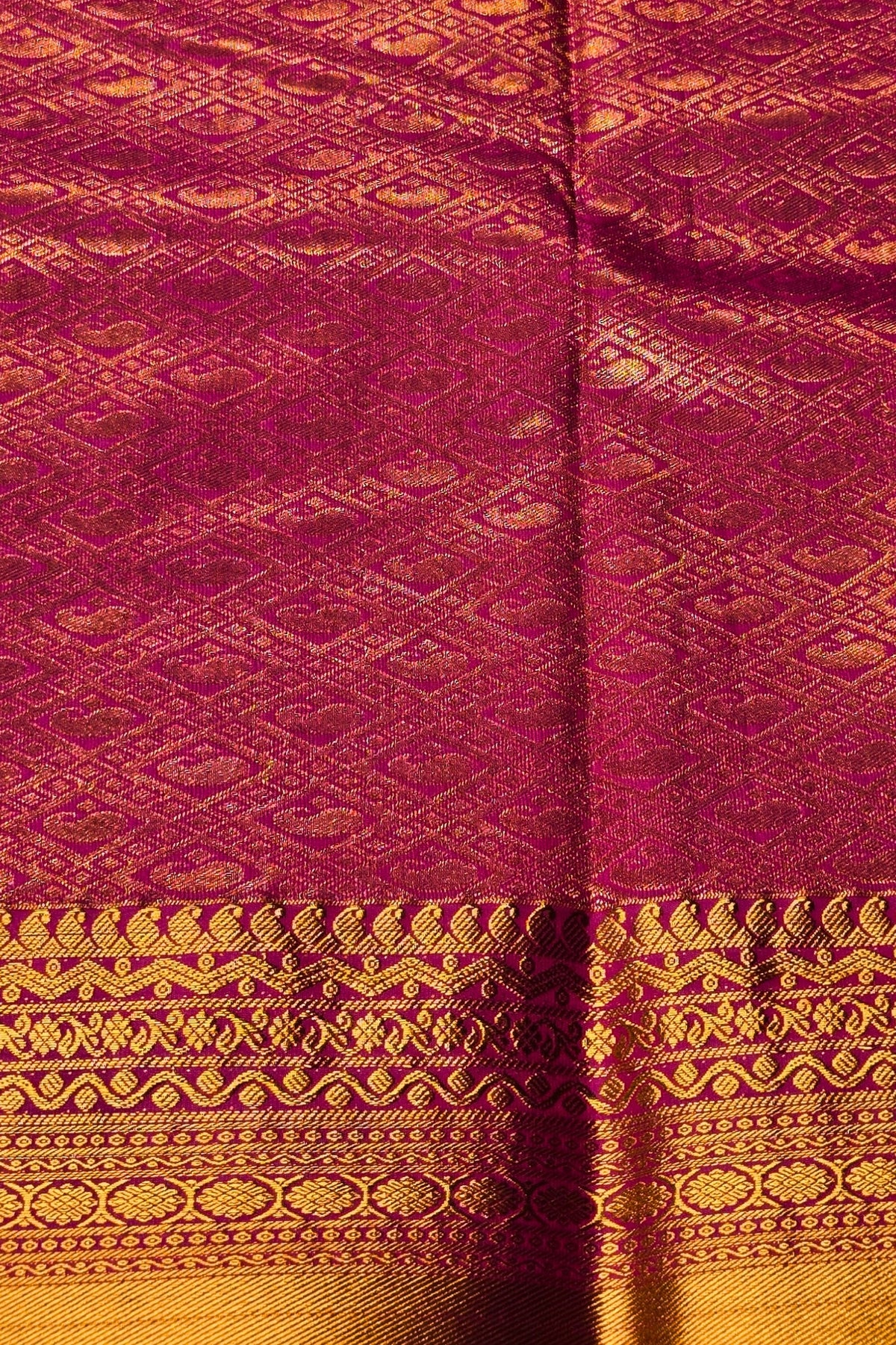 Close-up of maroon fabric with gold patterns